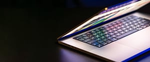 laptop-computer-with-halfopen-screen-dark-background-copy-space